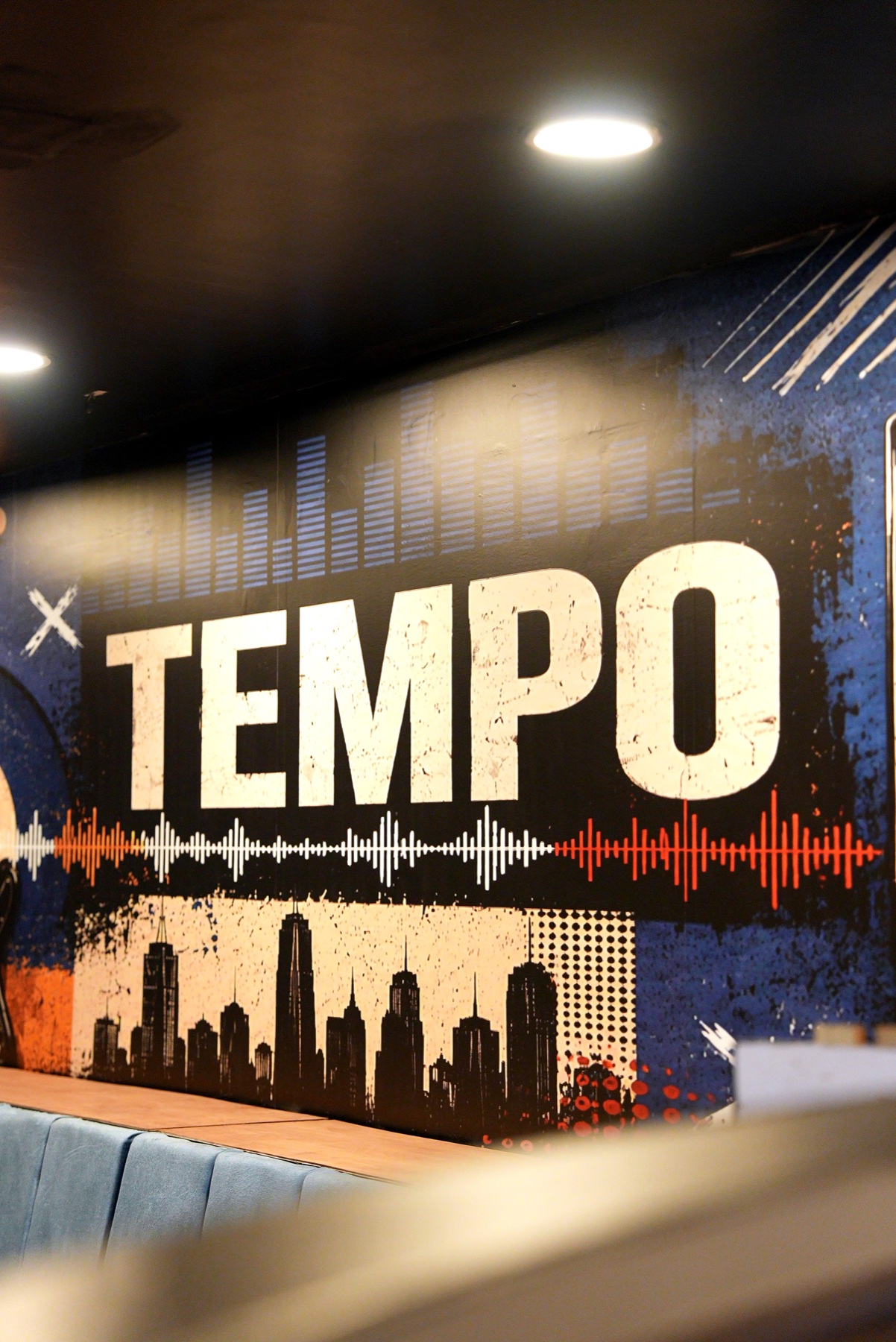 Tempo wall mural with skyline, waveform, and blue booth seating